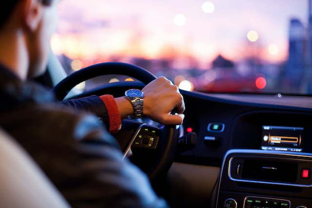 Homem com mão no volante de carro