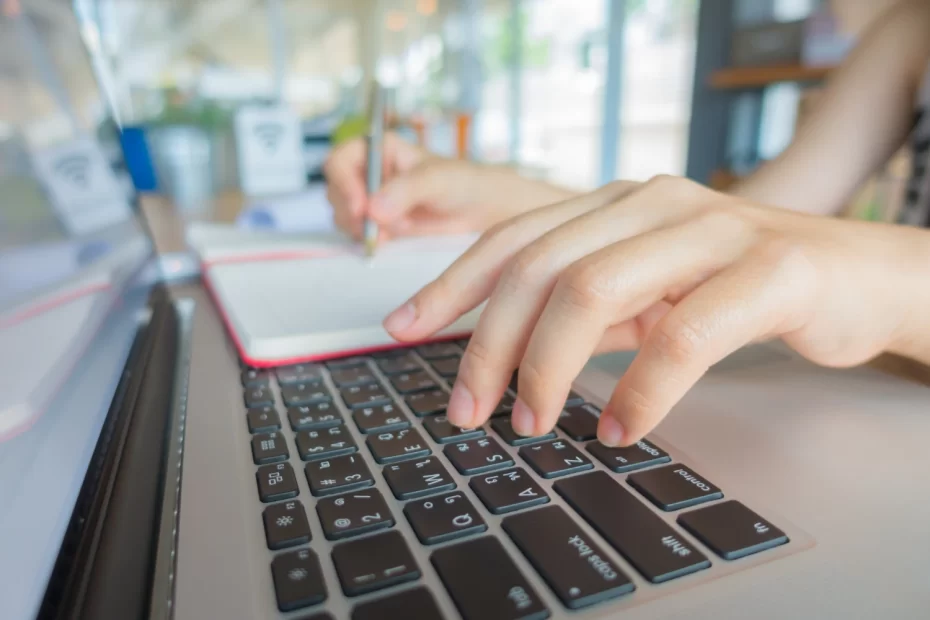 Pessoa digitando em laptop, ilustrando a estratégia de guest post que está levando pequenas indústrias ao topo do Google, com foco em otimização de SEO.