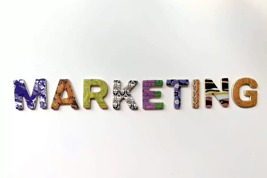 Imagem que destaca a palavra 'Marketing' em letras decoradas coloridas, simbolizando estratégias, crescimento e sucesso em negócios e marketing digital.